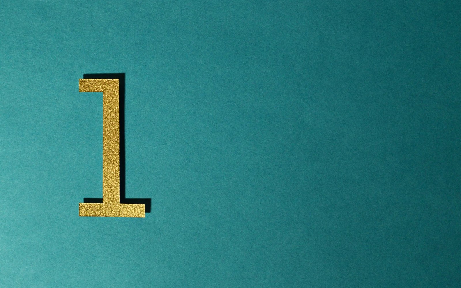 Gold number one figure casting a shadow on a teal background