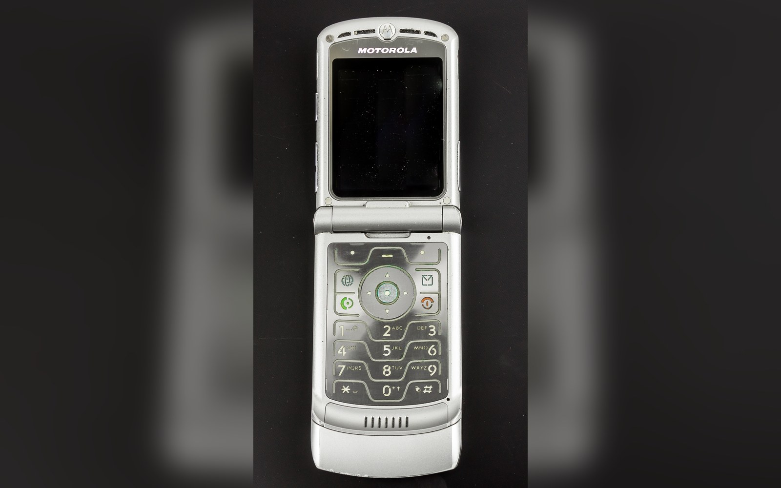 A silver Motorola RAZR flip phone open, showing its screen and keypad