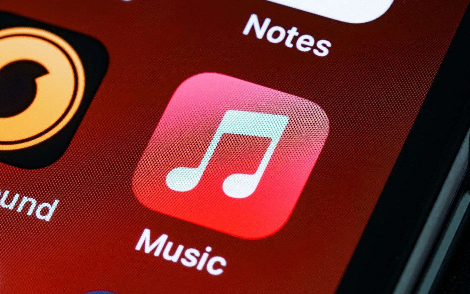 Close-up of the Music app icon on an iPhone home screen next to Notes