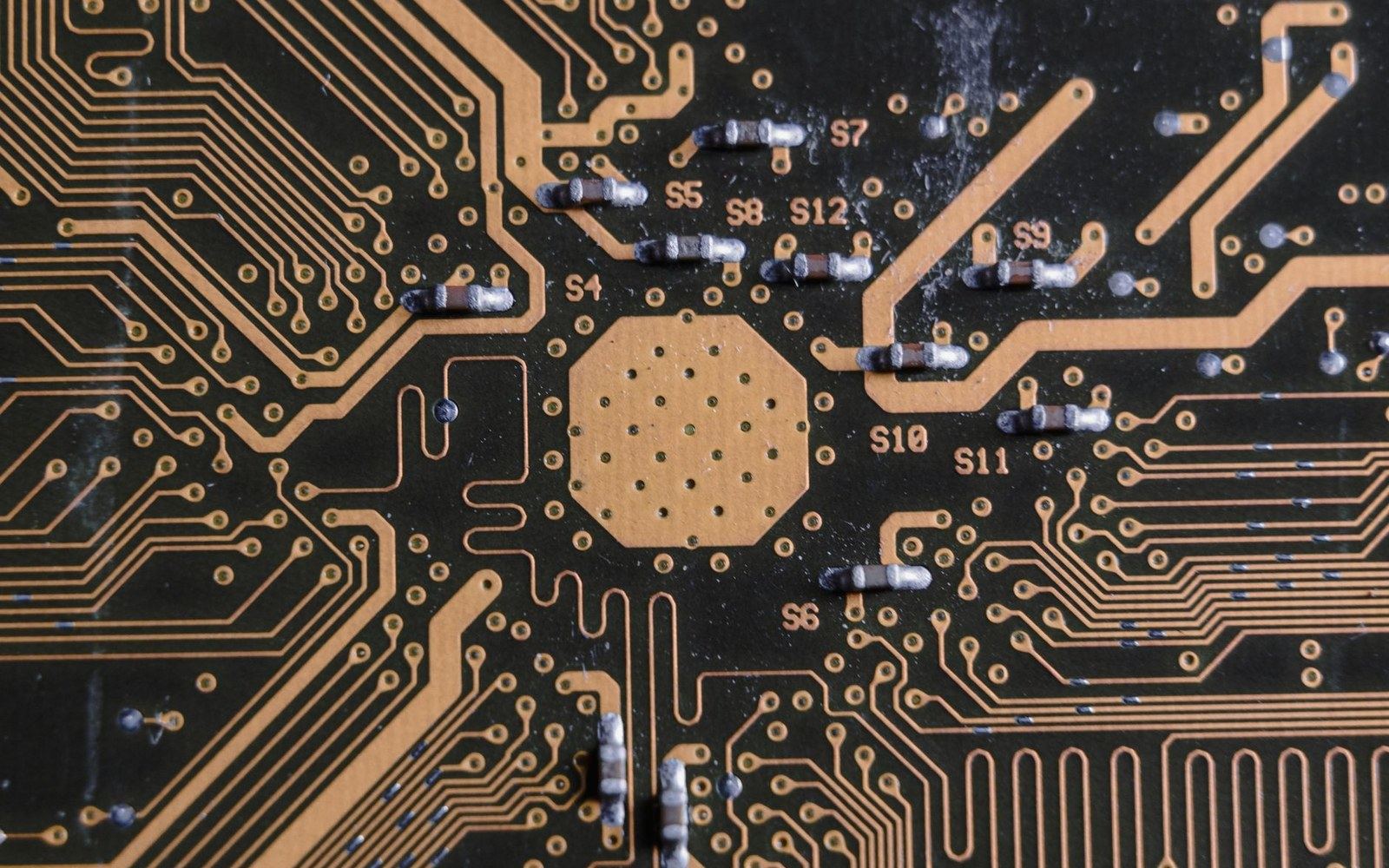 Close-up of a circuit board showing copper traces, solder points, and labeled resistors