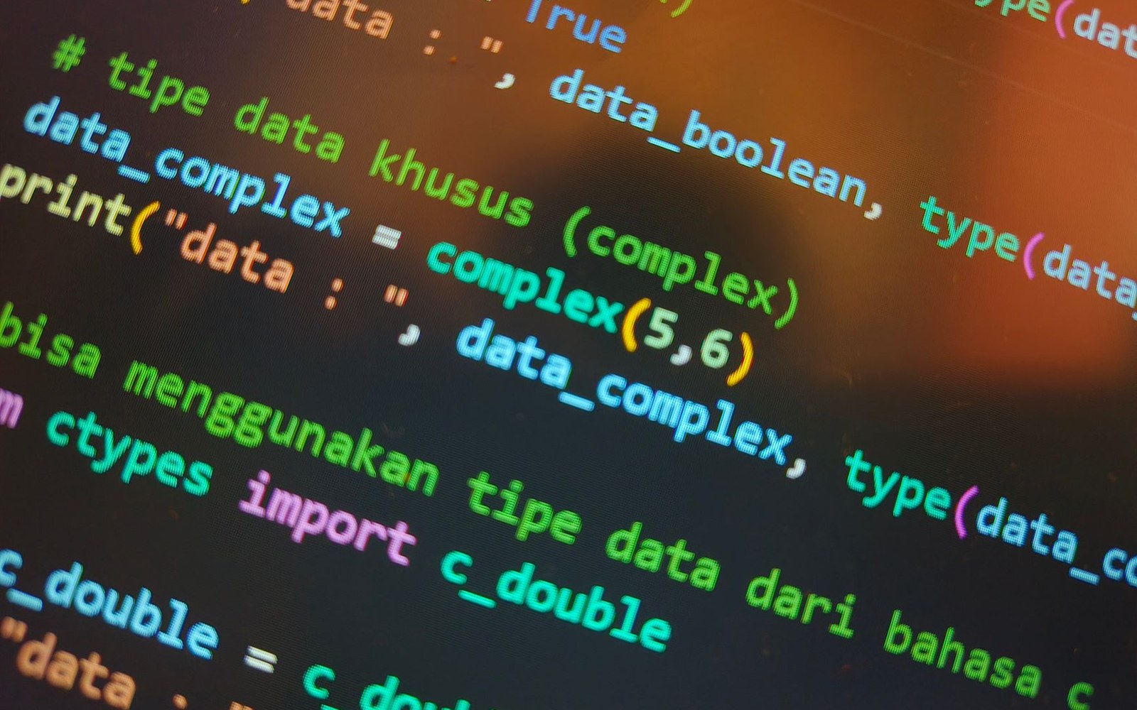 Close-up of a computer screen showing colorful Python code defining complex and double data types