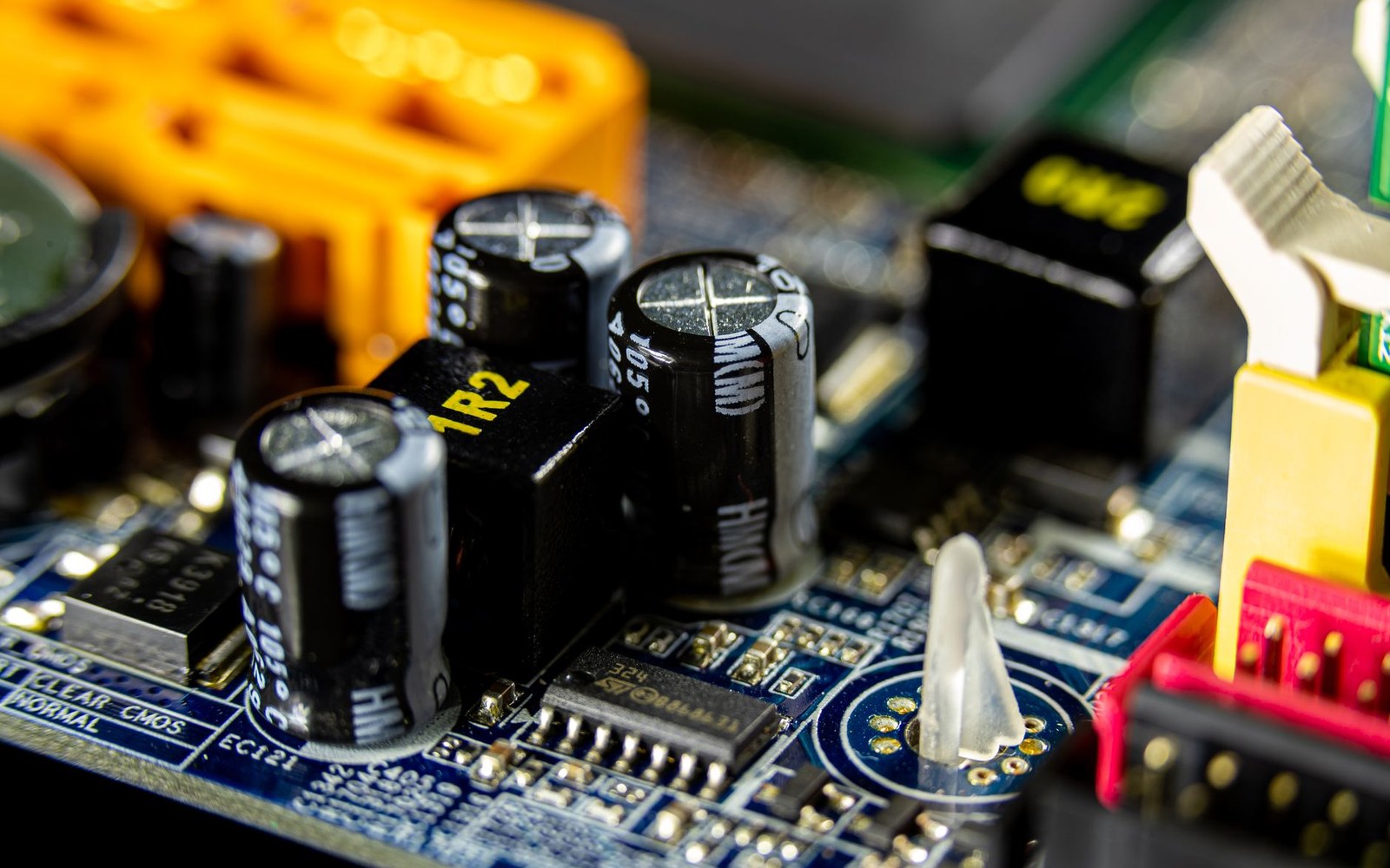 Close-up of capacitors, chip, and connectors on a computer motherboard's circuit board